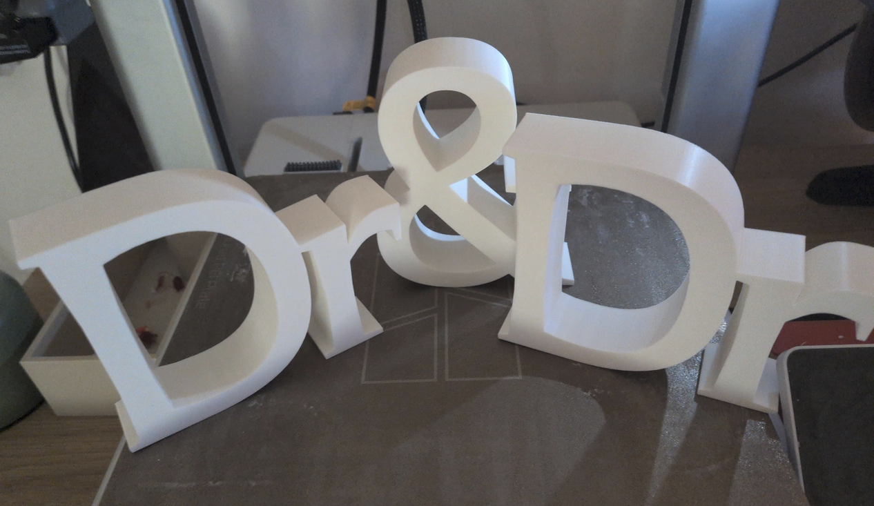 White 3D printed Dr & Dr freestanding letters on floor showing print quality